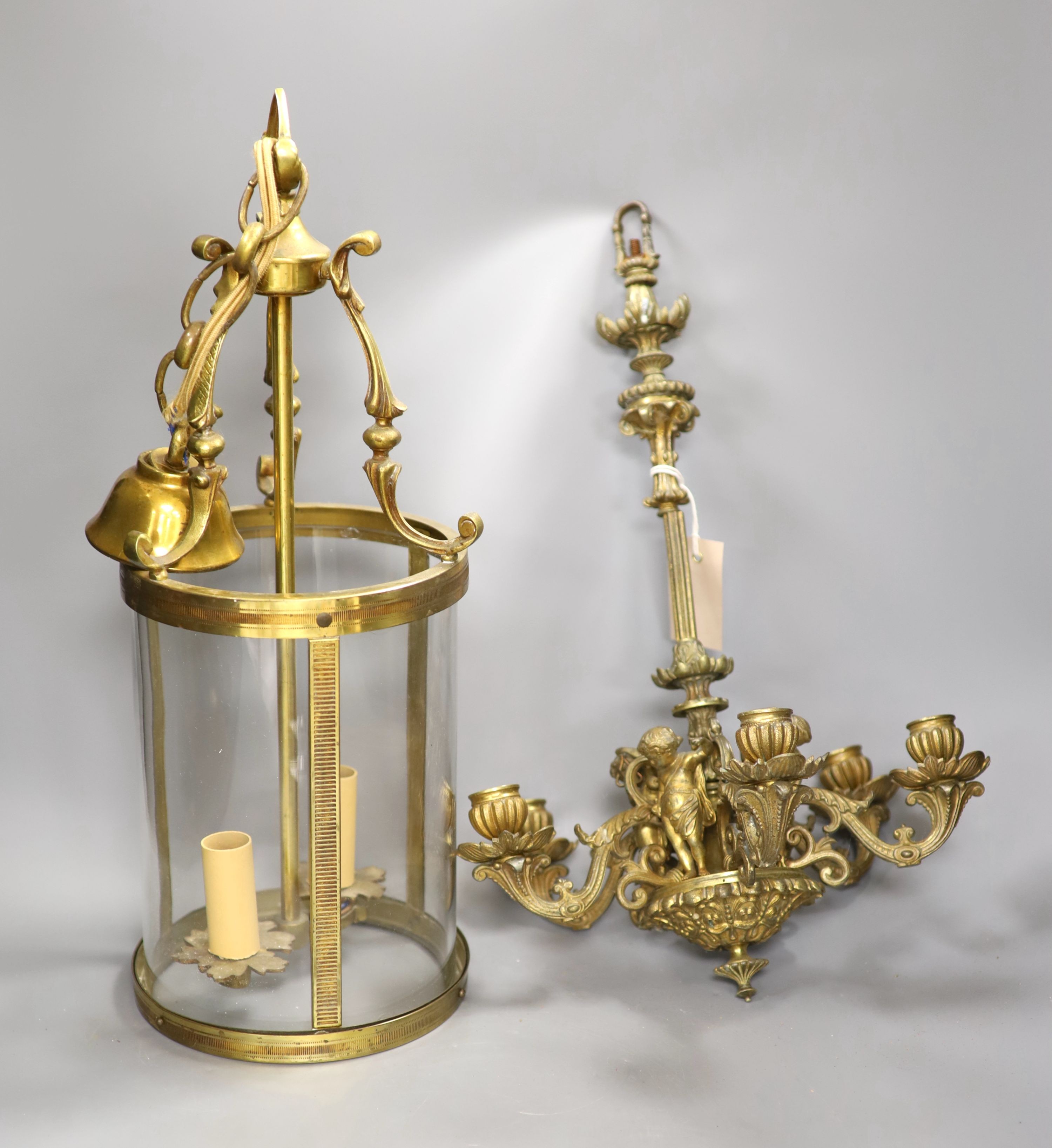 Two brass cylindrical hall lanterns, tallest 49 cm and a figural gilt metal chandelier
